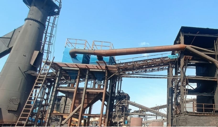 Industrial steel manufacturing facility showing large rotary kiln and multiple production units with metal structures and lighting systems in operation