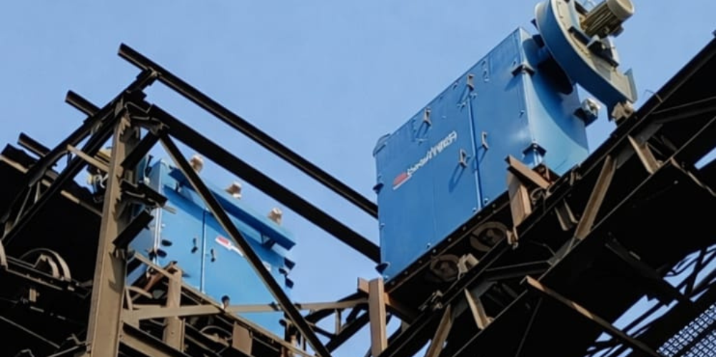 Industrial steel manufacturing facility showing large rotary kiln and multiple production units
